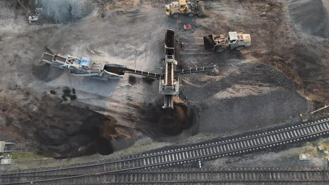 Heavy machinery loads gravel into an industrial screener, where vibrating belts sort and separate clean sand for construction use.

