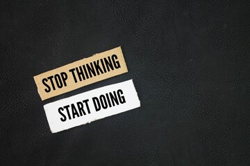 Paper with inspirational and motivational things or quotes stop thinking, start doing concept for...