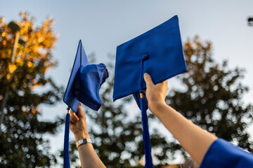 Graduation caps held high in celebration on a university campus