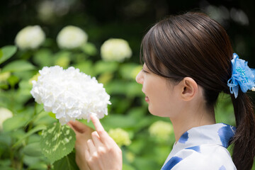 紫陽花を見る浴衣のかわいい女性のクローズアップ