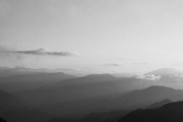 Landscape of the mountain range with sunlight beams through the haze at sunset