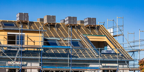 New building construction site with scaffolding and roof work in Waiblingen, Germany