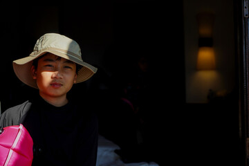  Asian boy wearing a brown hat is preparing to row a boat at the beach on Koh Kood.