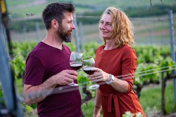 happy couple tasting wine in a vineyard