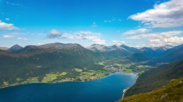 Timelapse of moving clouds viewed from Nesaksla mountain above Isfjorden village and Romsdalsfjorden with surrounding valleys and peaks in Norway. 4K UHD video.