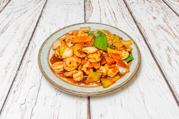 A plate full of shrimp stewed with vegetables and spicy sauce