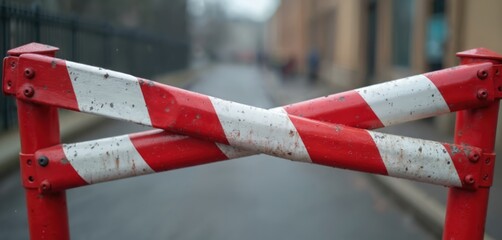 Close-up of red-white striped barricade. Metal frame, caution sign. Barrier construction site protection. Safety, security, warning, restricted area. Blockade with limit, no entry.