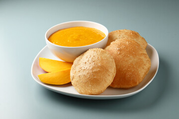 Aam ras served with puri and slice of mango. Delicious Indian Snack 