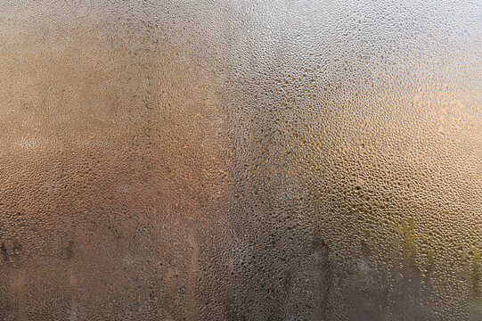 natural condensation forming on cold glass surface. water droplets, creating an abstract pattern. Cool atmosphere with transparent effect. drops on foggy window, blurring outside view. wet window.
