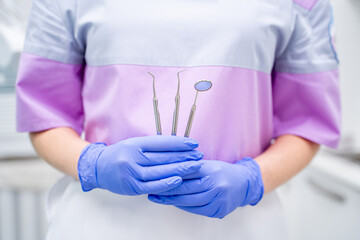 Dental tools are skillfully held by a knowledgeable professional inside a clinic setting