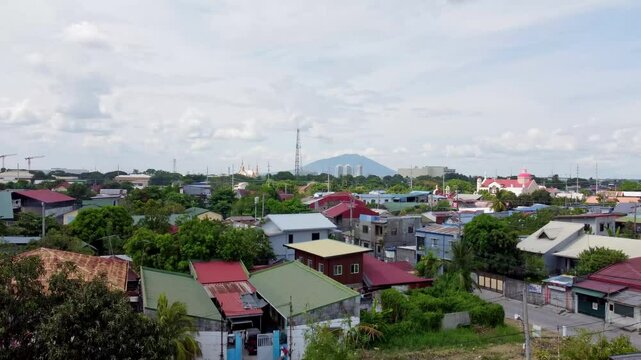 View of the city of San Fernando, Pampanga, The Philippines. Camera rises from behind trees to reveal the city, with Mount Arayat in the distance