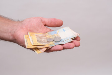 Hand holding assortment of Ukrainian hryvnia cash - mixed bills and coins in tight composition. for...
