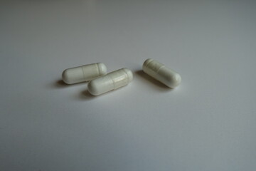 Close view of three white capsules of acetyl cysteine dietary supplement