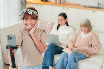 Fototapeta premium An Asian family multi genersation broadcast and vlogging in the living room during the celebration Senior woman and nephew vlogging using social media online conversation to her follower at home 
