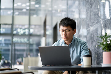 asian businessman working on laptop in office