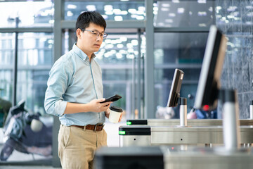 asian businessman Pass through the automatic turnstile using facial recognition