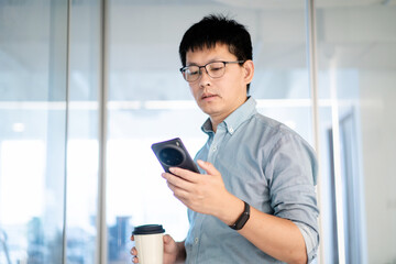Fototapeta premium asian businessman using smart phone in office