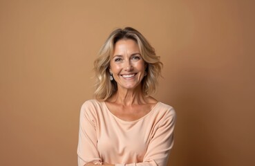 Portrait of beautiful middle-aged woman smiling at camera. Blond hair, positive emotions, happy face with cheerful expression. Confident female in forties against neutral brown background. Ideal for
