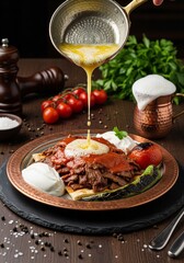 Traditional Turkish cuisine food iskender kebab with melted butter, sauce, pita bread, tomato, pepper and yogurt.