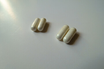 Two pairs of white capsules of acetyl cysteine dietary supplement
