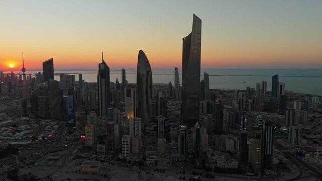 Breathtaking 4K drone shot of Kuwait City at sunrise. Towers glow under golden skies with the calm Gulf in the background. Ideal for cinematic, travel, or architectural footage.