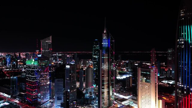 Dazzling 4K aerial of Kuwait City glowing at night. High-rise towers, colorful lights, and urban vibrance captured in cinematic detail. Great for city, travel, and commercial footage.