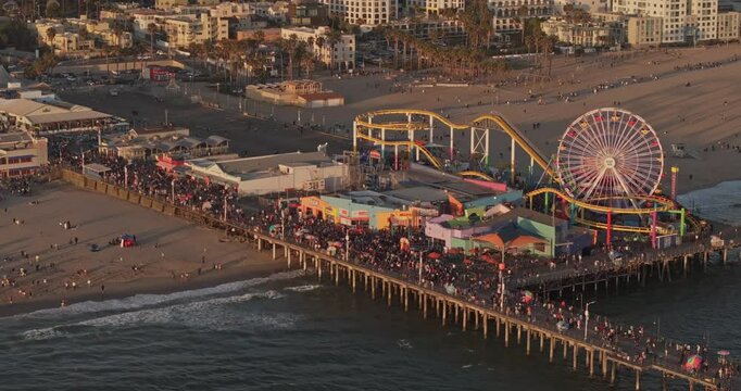 Santa Monica California Aerial v18 zoomed birds eye view flyover and around state beach capturing Pacific park on the pier, packed with visitors at sunset - Shot with Mavic 3 Pro Cine - May 25th 2024