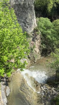 Waterfall in Tbilisi botanical garden top view, vertical