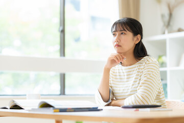 部屋で勉強をする大学生の女性