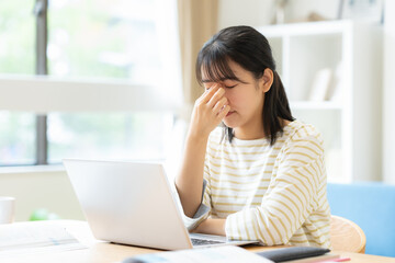 部屋で勉強をする大学生の女性