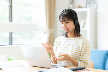 部屋で勉強をする大学生の女性