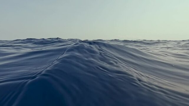 Slow motion of smooth swell waves on surface of deep blue ocean water of Timor-Leste in Southeast Asia
