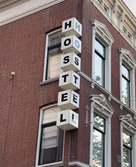 Hostel sign on brick wall building facade, Netherlands, Holland. Travel and accomodation