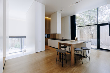 There is a kitchen that features a table along with stools placed in it