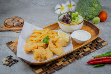 Crispy battered fish served with golden fries, tartar sauce, and lemon slices. A classic British...