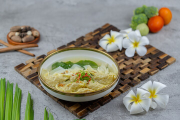 Warm and flavorful wonton soup with meat-filled dumplings, clear broth, and vegetables. Perfect for Asian food themes, menus, or food photography projects.
