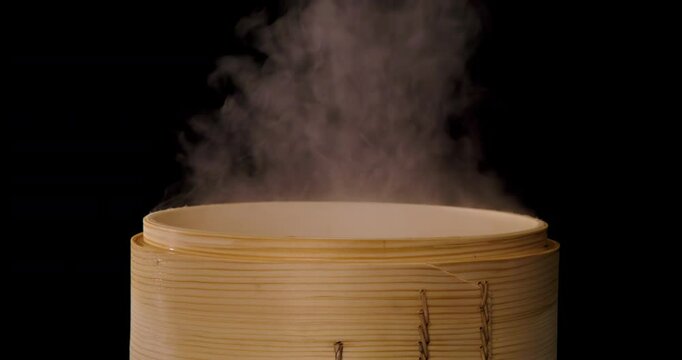 Opening the traditional bamboo steamer releases a large amount of steam