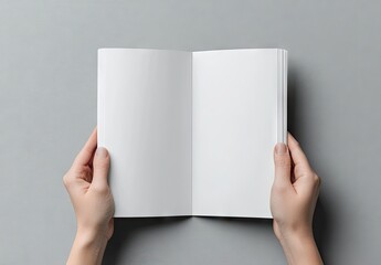 Hands holding open blank brochure on gray background