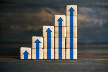 Wooden blocks stacked as blue arrow bar chart