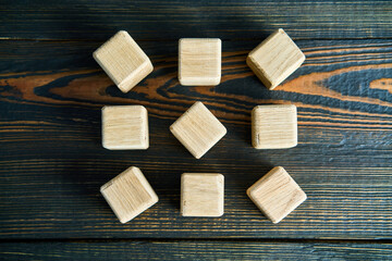Top view of wooden blocks arranged in circular pattern on wooden background