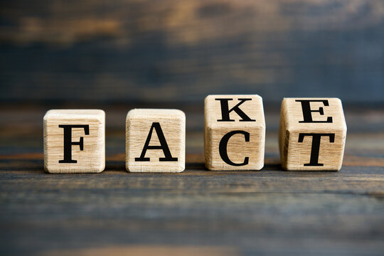 Flipping wooden cube blocks with FAKE to FACT text on wooden background