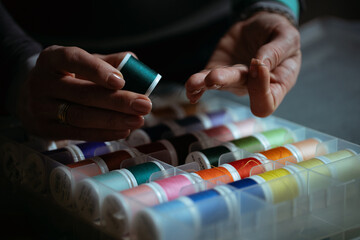 Detailed close-up photograph showing hands guiding fabric through an industrial sewing machine. The image captures the precision and craftsmanship involved in textile production and tailoring. Ideal f