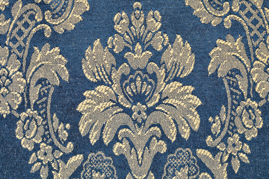 particular of a strip of elegant damask silk fabric with golden floral pattern on blue background