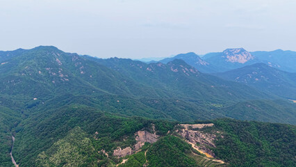 Fototapeta premium Aerial Drone Footage of Rugged Mountain Terrain and Lush Forest Slopes in Mungyeong, Korea – Scenic Nature and Rock Formations