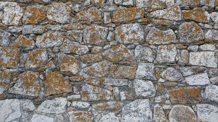 Primer plano de una pared rústica de piedra, textura rugosa, ideal para fondos arquitectónicos y...