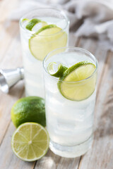 Gin Fizz cocktail with lime on wooden table