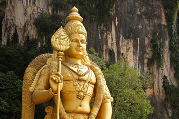Golden statue of Lord Murugan (Kartikeya) towering at Batu Caves Hindu Temple, Kuala Lumpur, Malaysia.