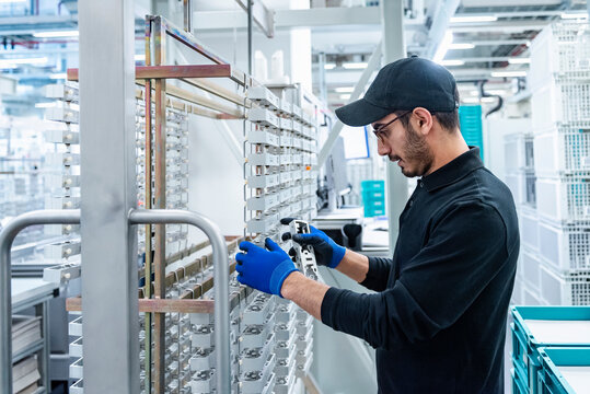 Factory worker in a production hall working with machinery
