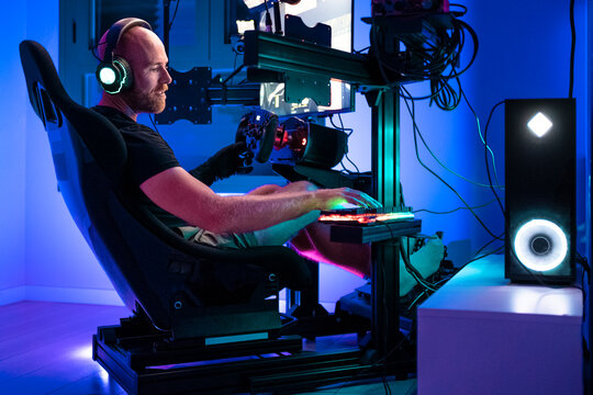 Male gamer playing video game on computer at studio