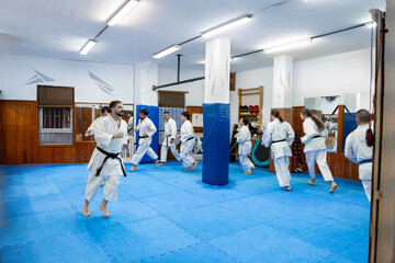 Karate students jogging to warm up in dojo before training